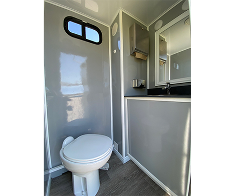 toilet and sink inside bathroom trailer